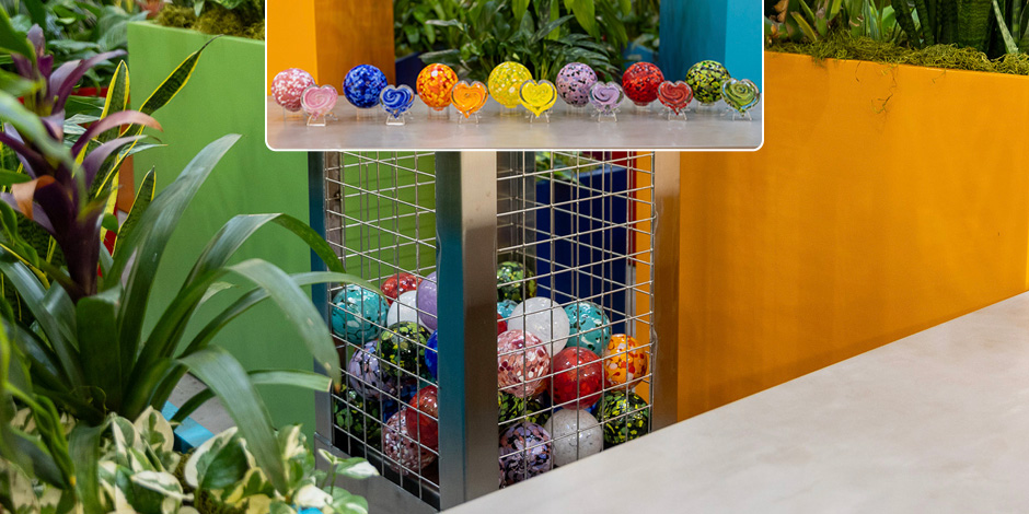 Colorful hearts and floats and a gabion surrounded by plants.